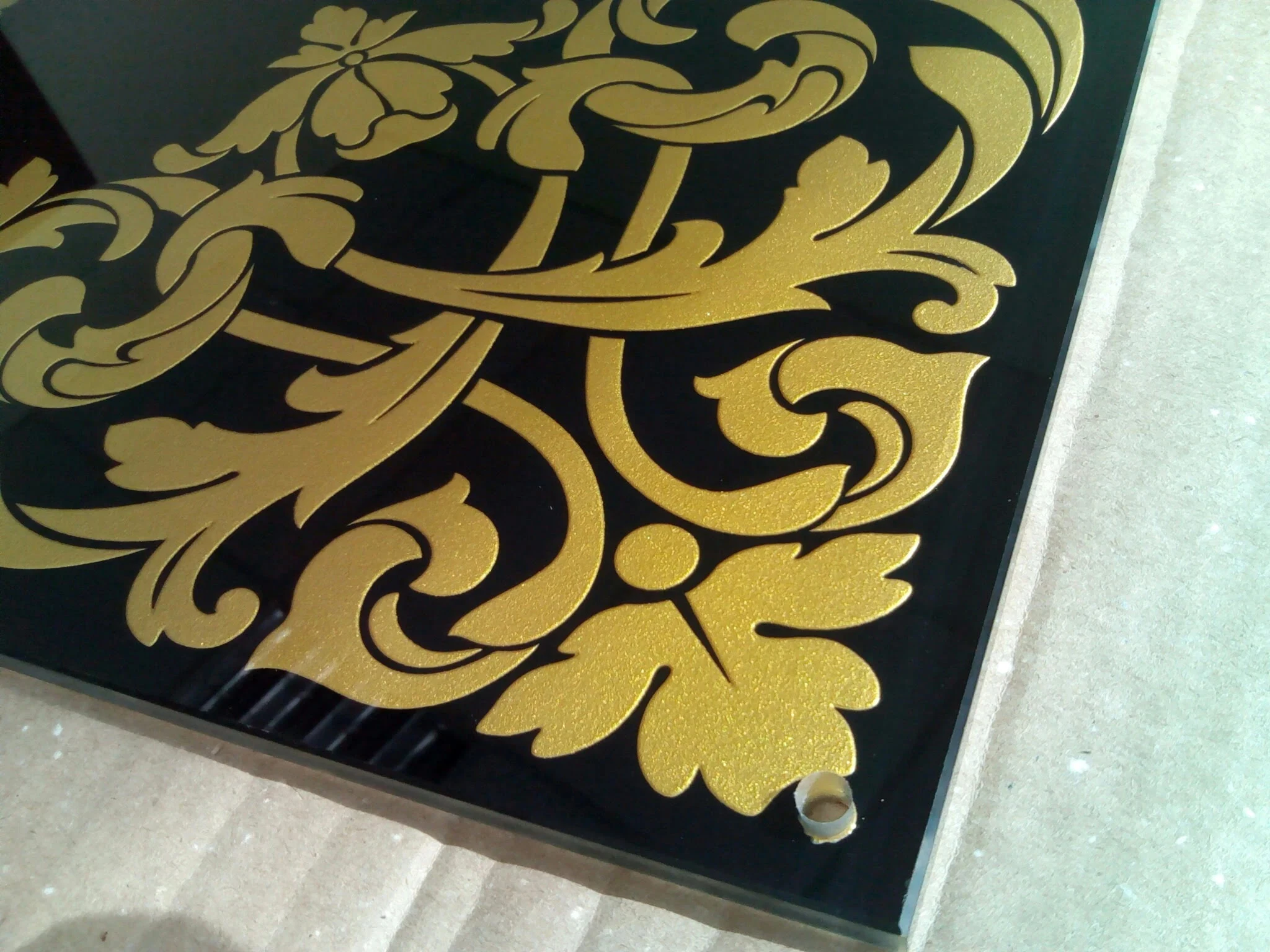 Столешница из черного стекла с глубоким пескоструйным рисунком, крашеным в золотистый цвет